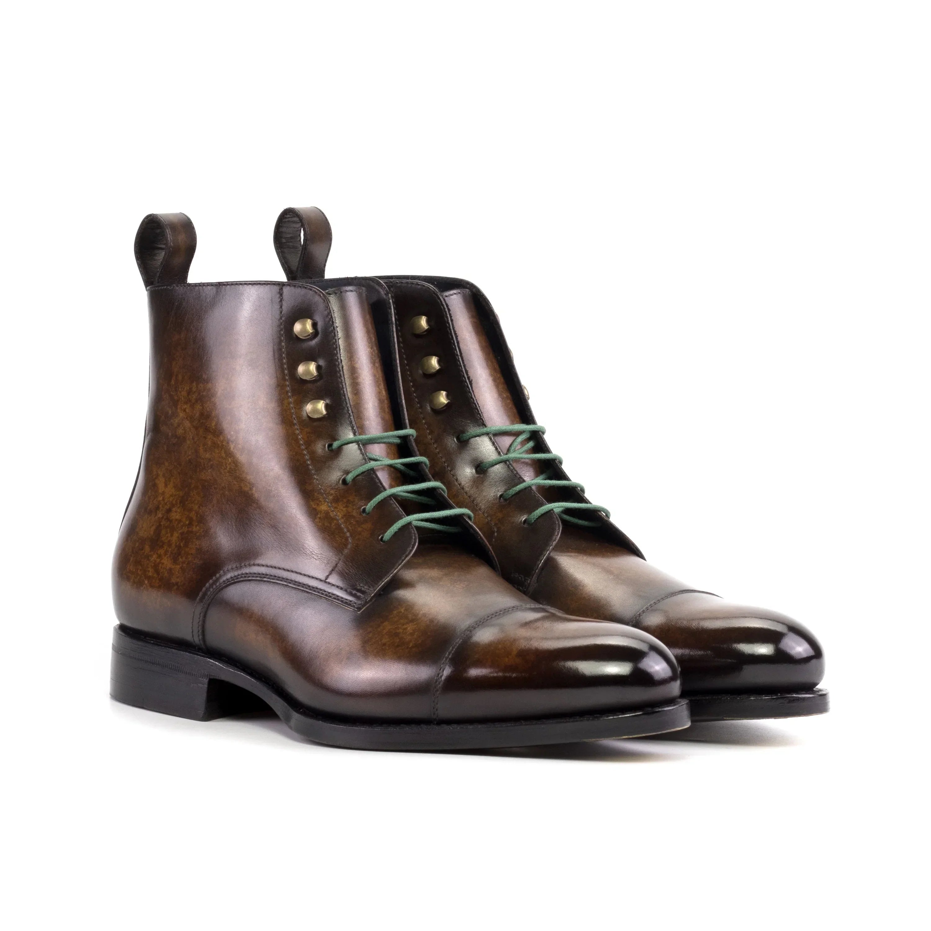 Brown leather chukka boots with green laces and brass eyelets.