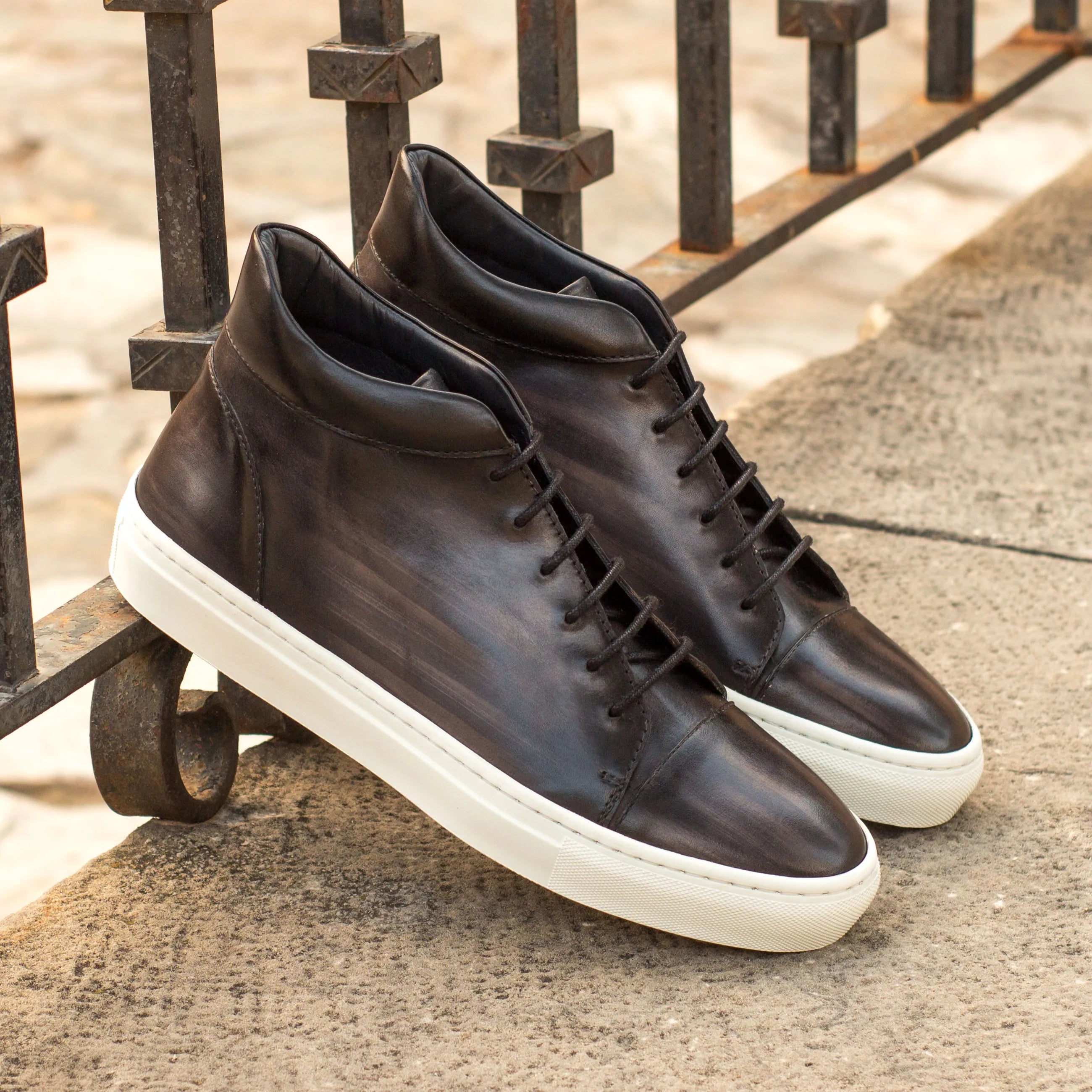 Pair of Donny Patina high top dark leather sneakers